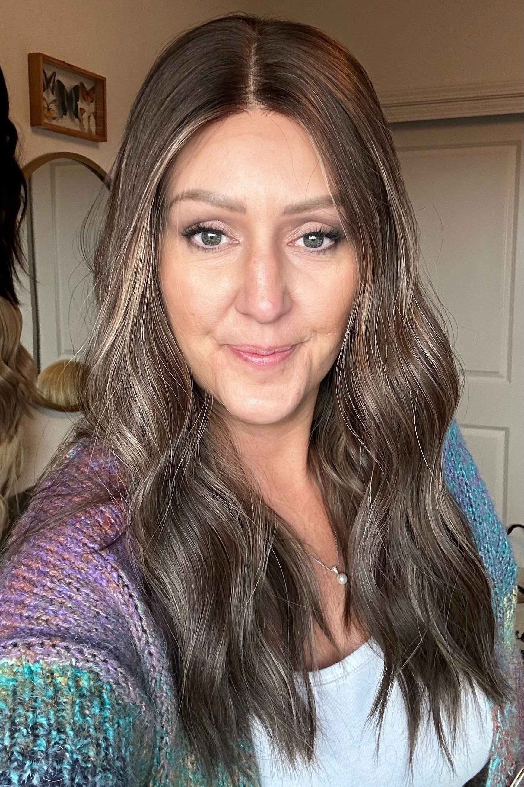 Woman with long brown hair in a room with a neutral background
