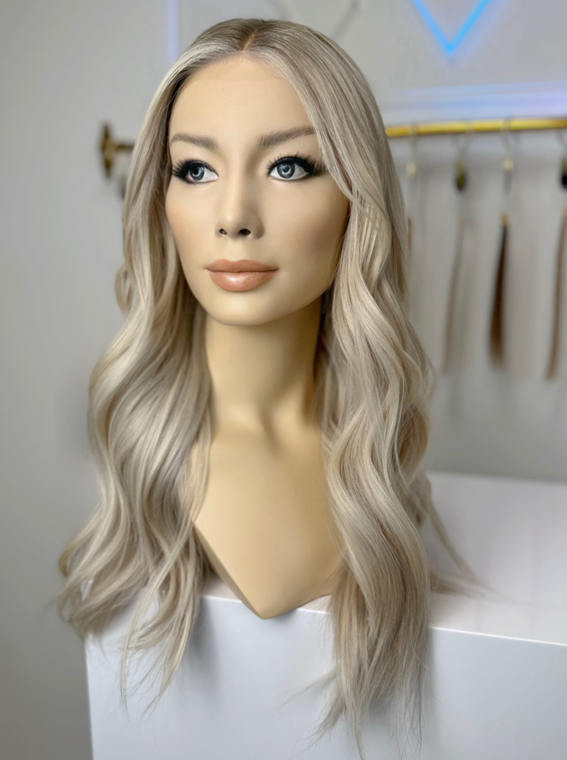 A mannequin head wearing a rooted cool blonde 22 inch wig ￼